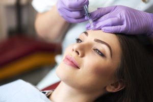 Young woman on a beauty treatment with the filler injection at the beauty clinic.