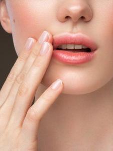 Part of woman's face. Woman's lips, nose and hand. Soft skin.