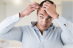 Man checking hairline, in a bathroom