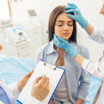 two doctors are examining her face and making notes