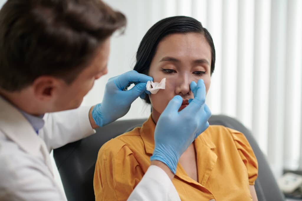 Surgeon Examining Nose of Patient