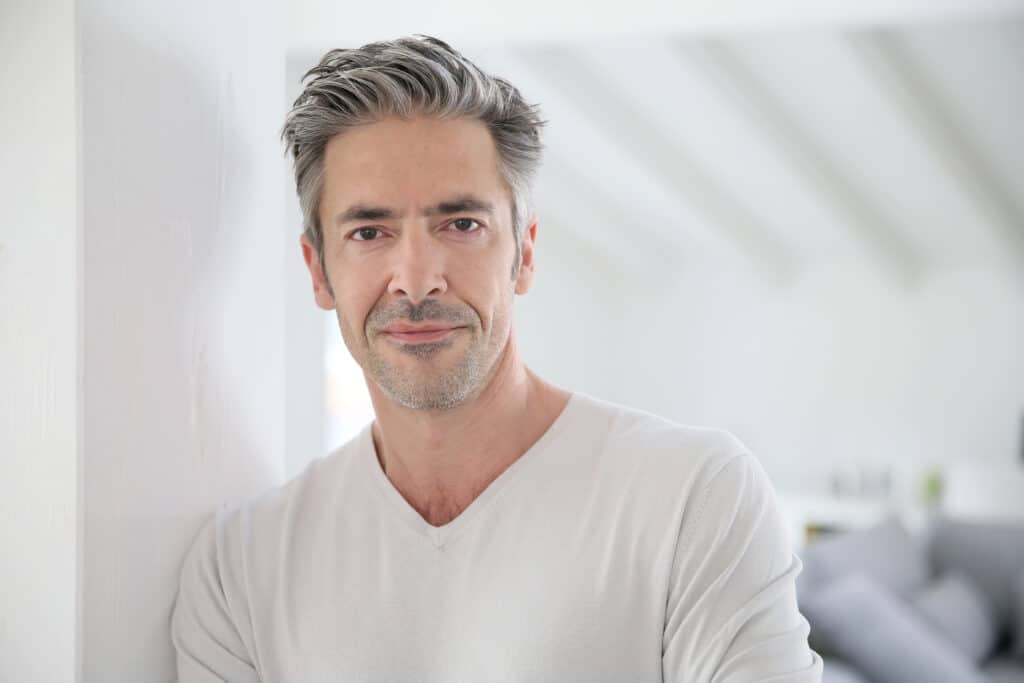 A man smiling and showing the results of a facelift in Lewisville