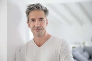 A man smiling and showing the results of a facelift in Lewisville