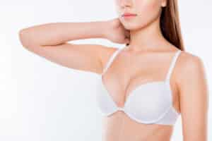 A cropped shot of a woman in a white bra after a breast lift in Dallas