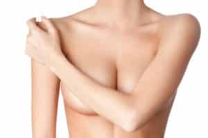 A woman covering her breasts with her arm after a breast lift in Lewisville